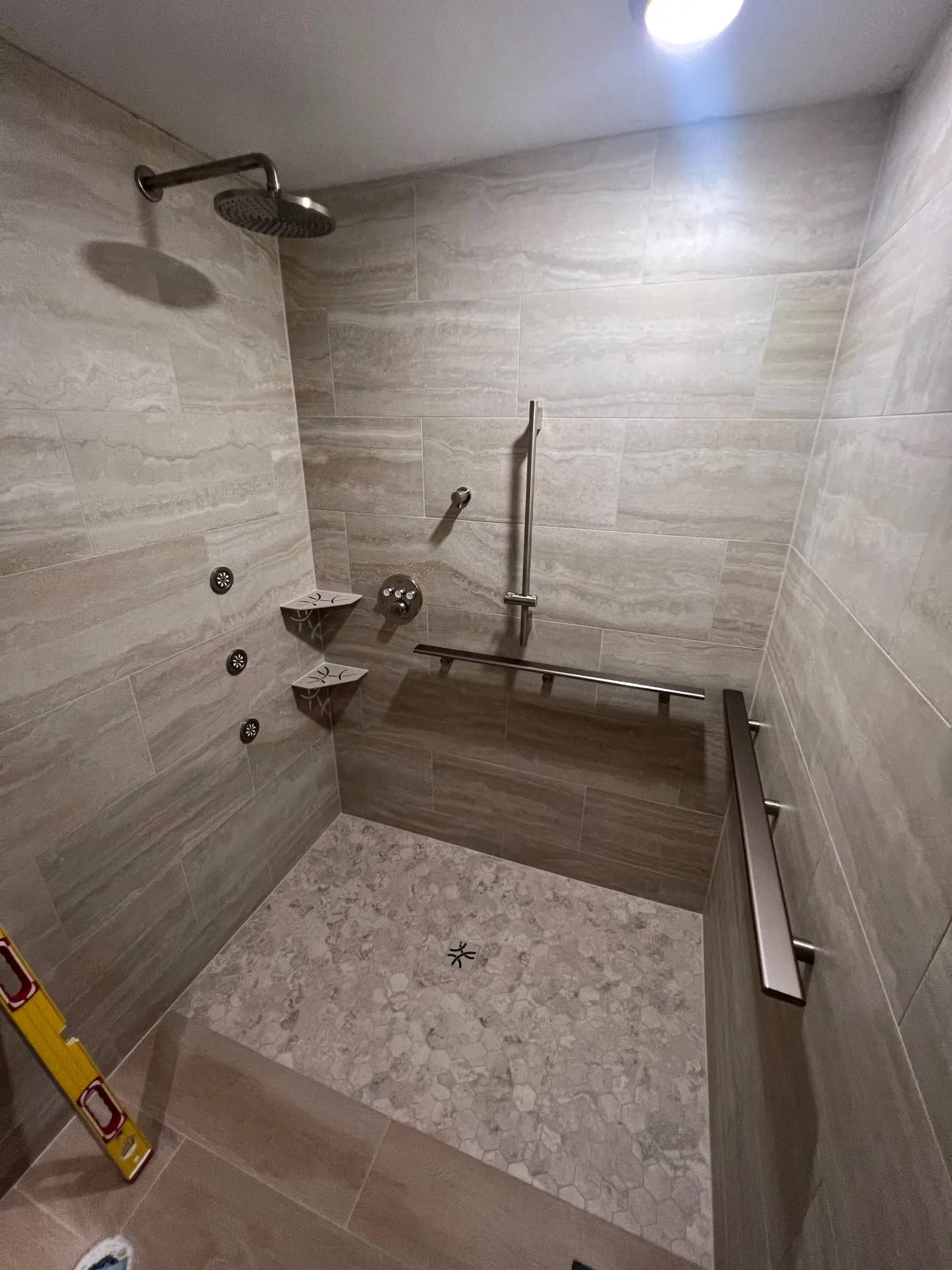 Accessible shower during final work, with the rain head and body sprays installed