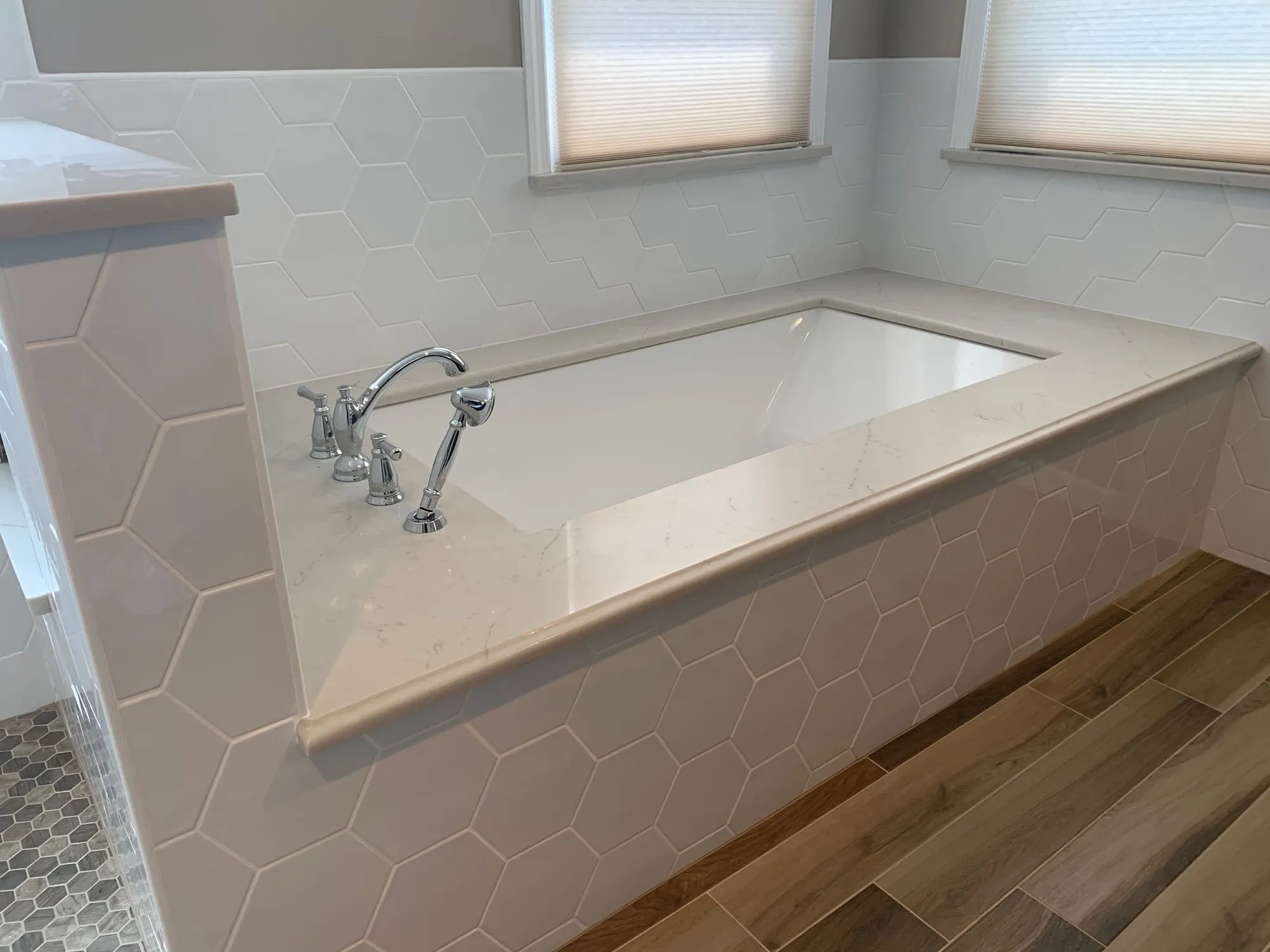 Wood-look floor tile meeting a tiled tub surround