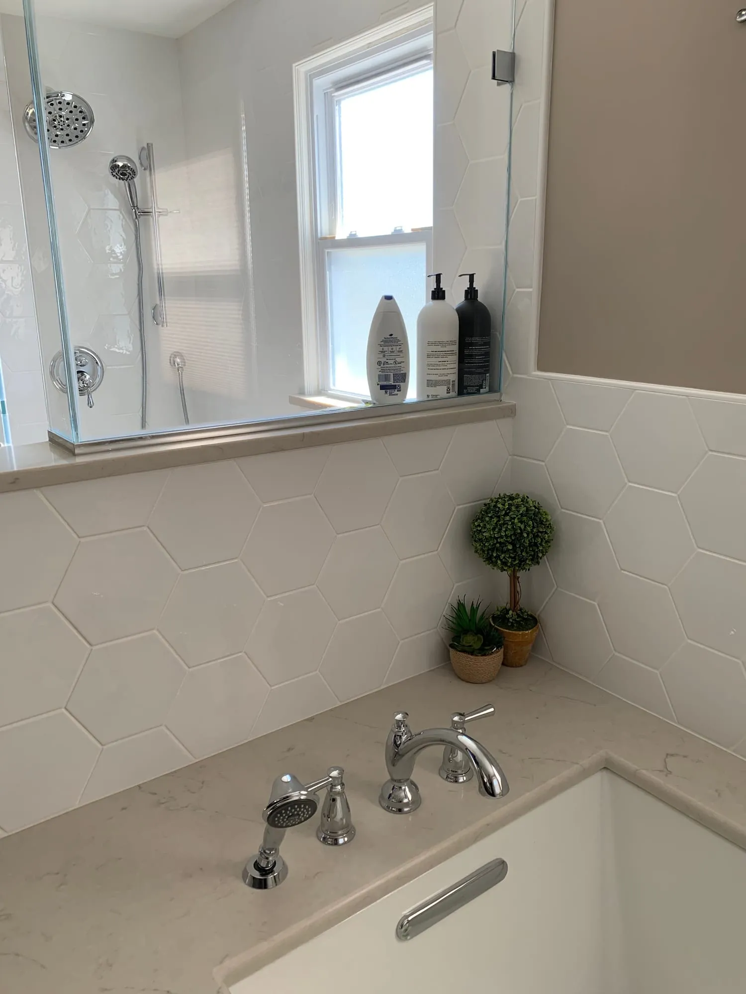 Tub deck detail with fixtures and white hexagon tile