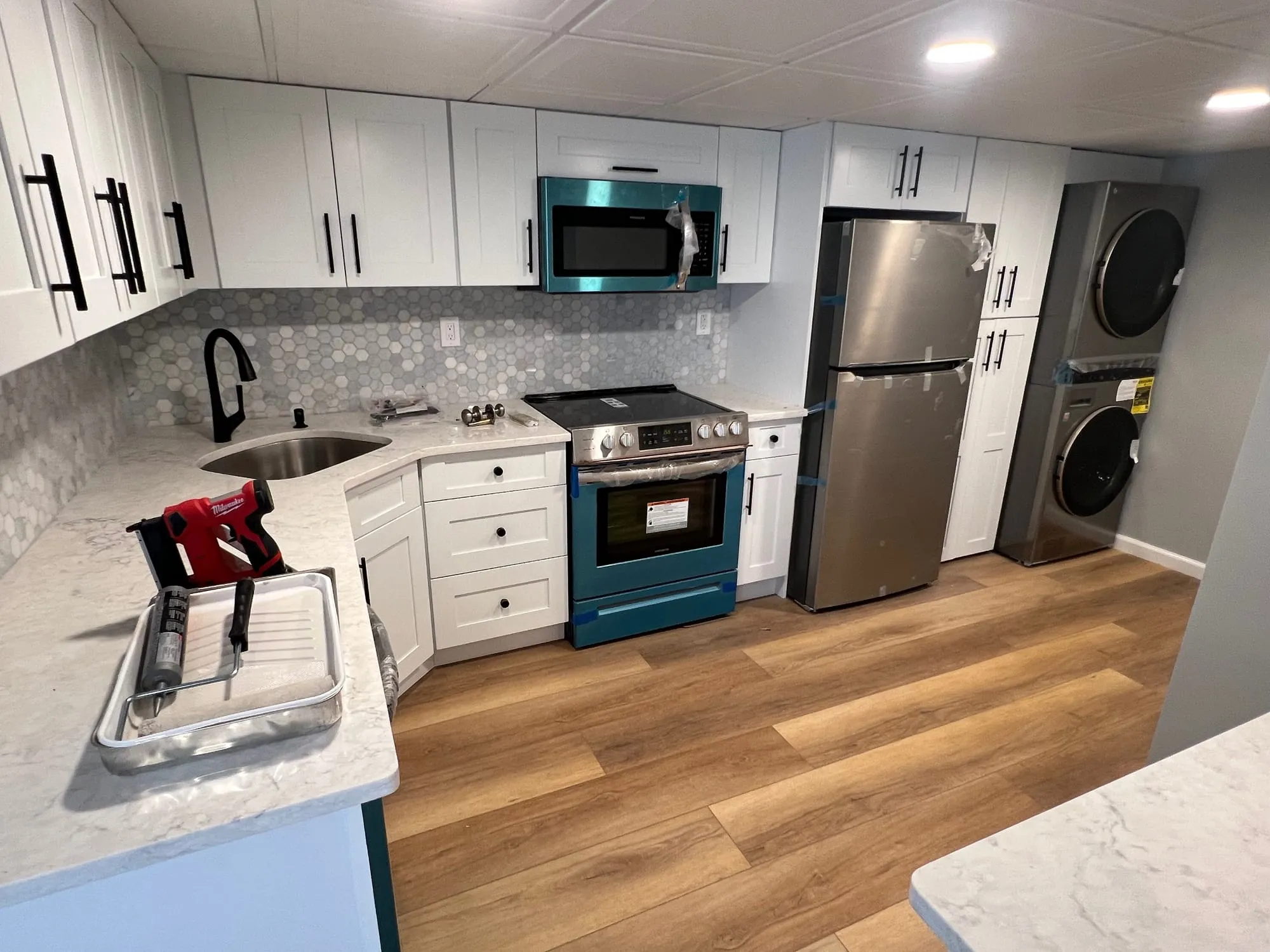 Bay Shore basement kitchen with white shaker cabinets and stainless appliances