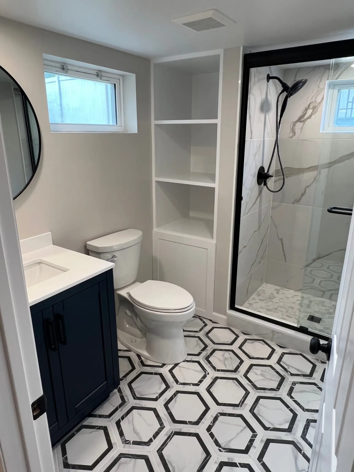 Black-and-white hexagon floor tile in a basement bathroom