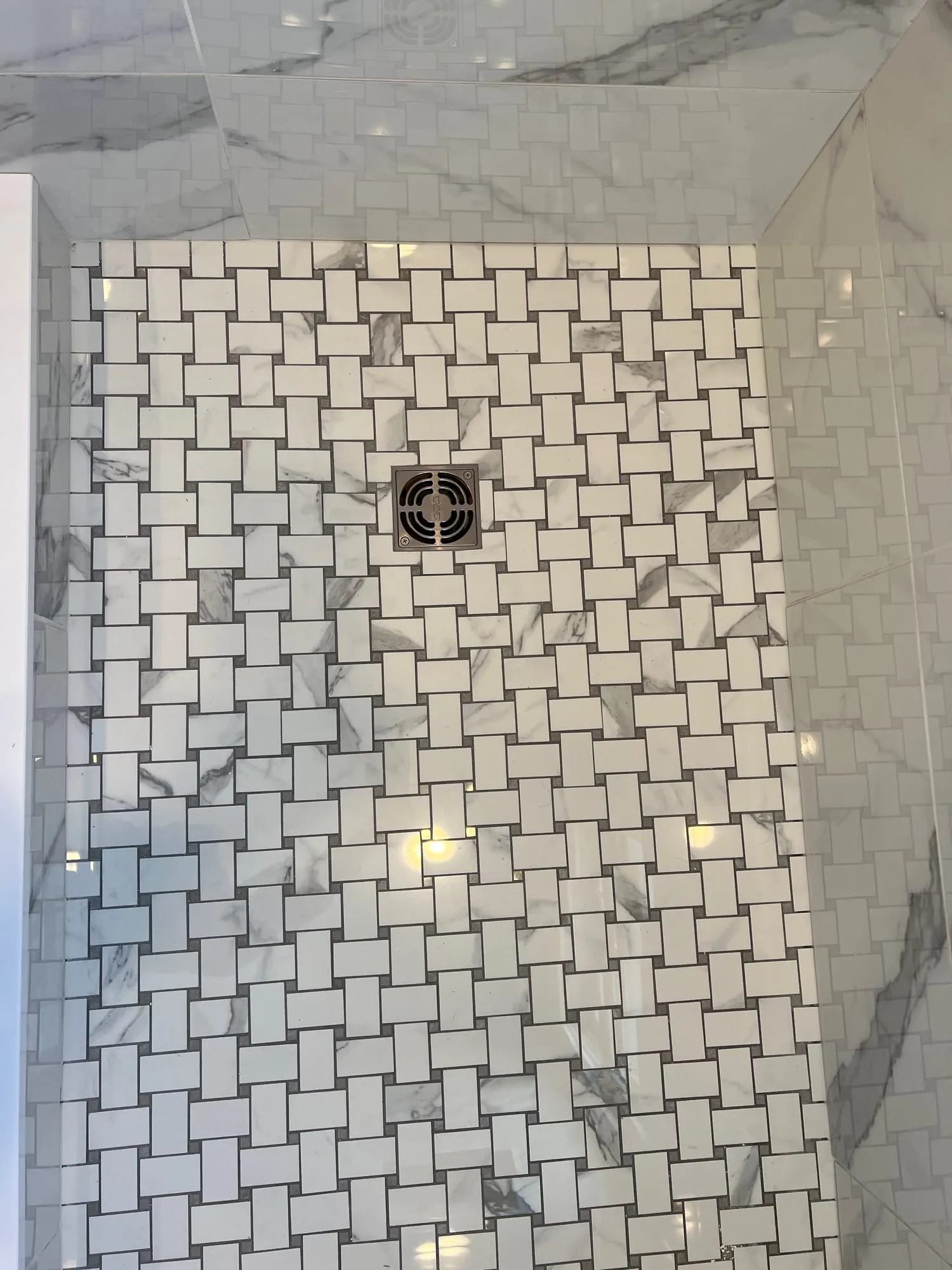 Basketweave marble mosaic shower floor and marble-look wall tile