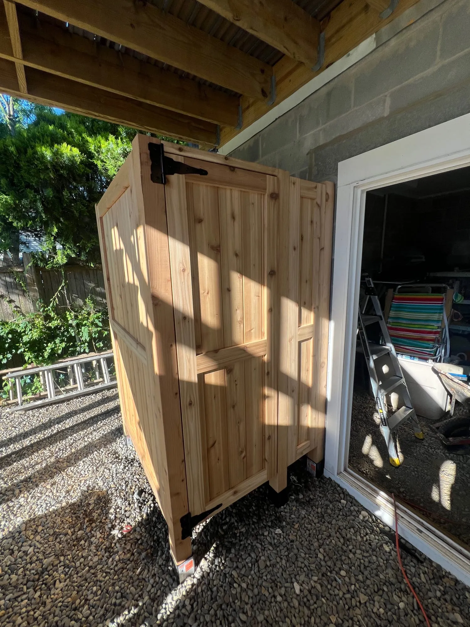 Cedar outdoor shower enclosure beside the house