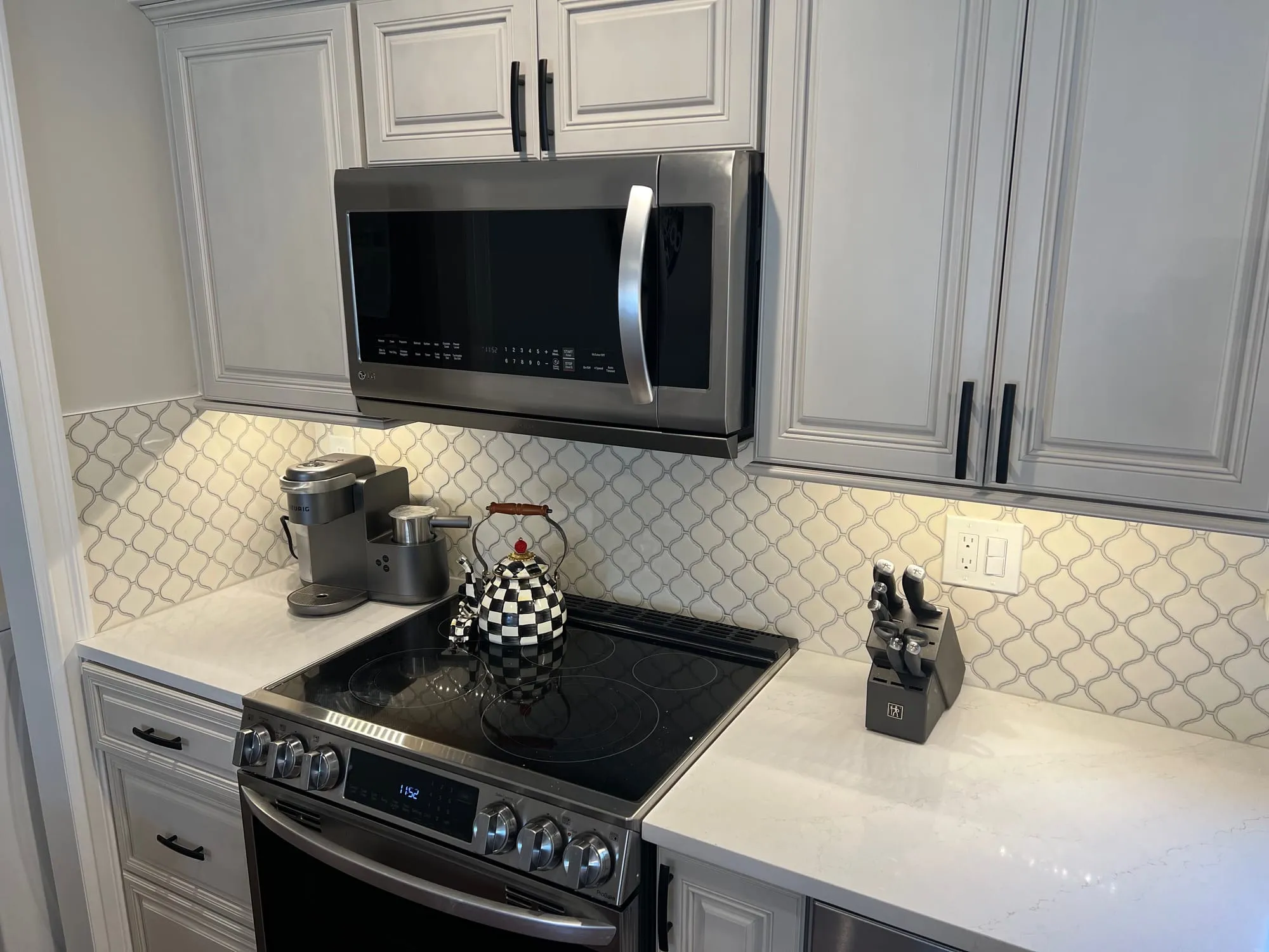 Range wall in a renovated Dix Hills kitchen with arabesque tile and white countertops