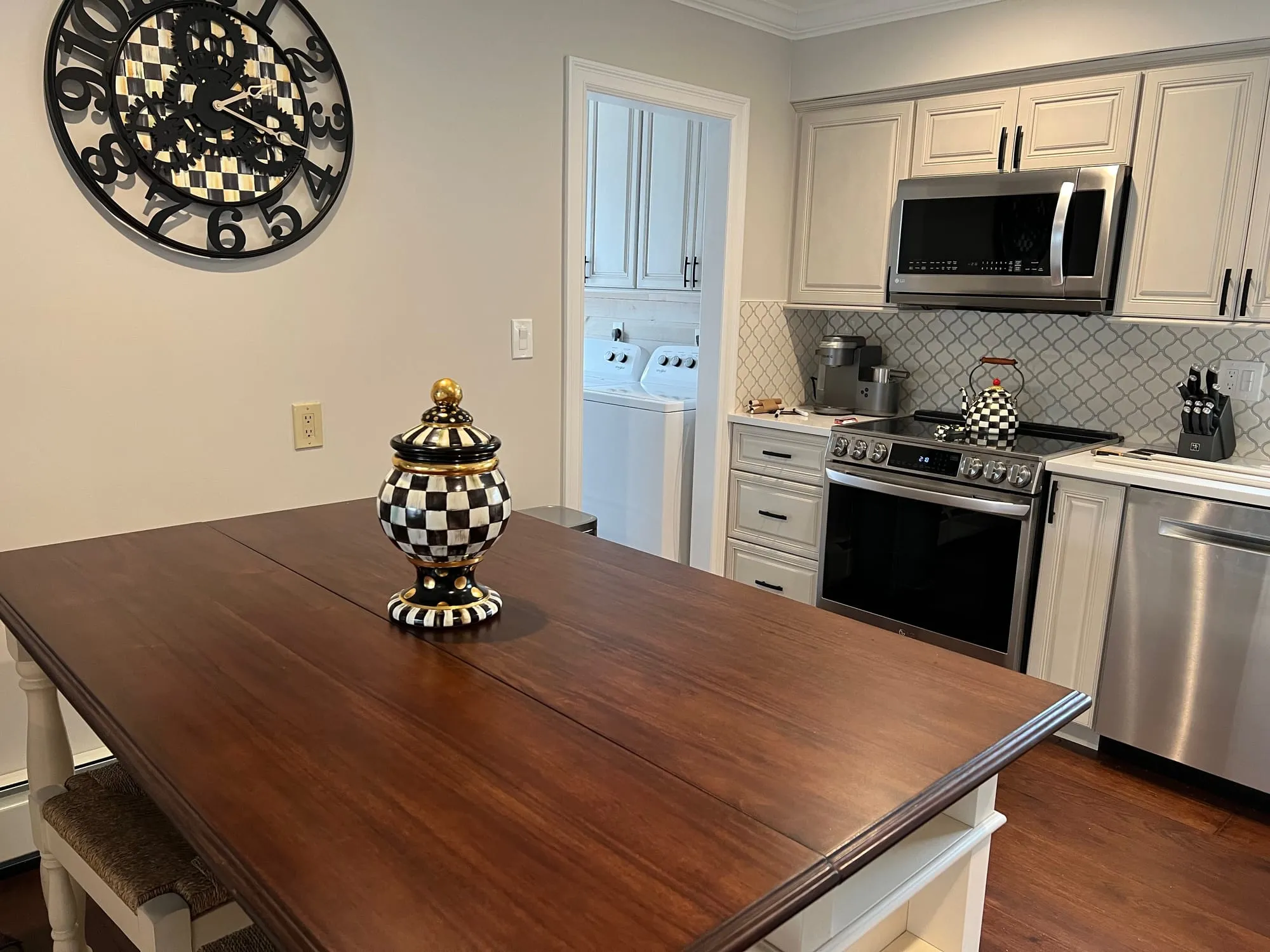 Kitchen island with a wood top over dark hardwood flooring in Dix Hills