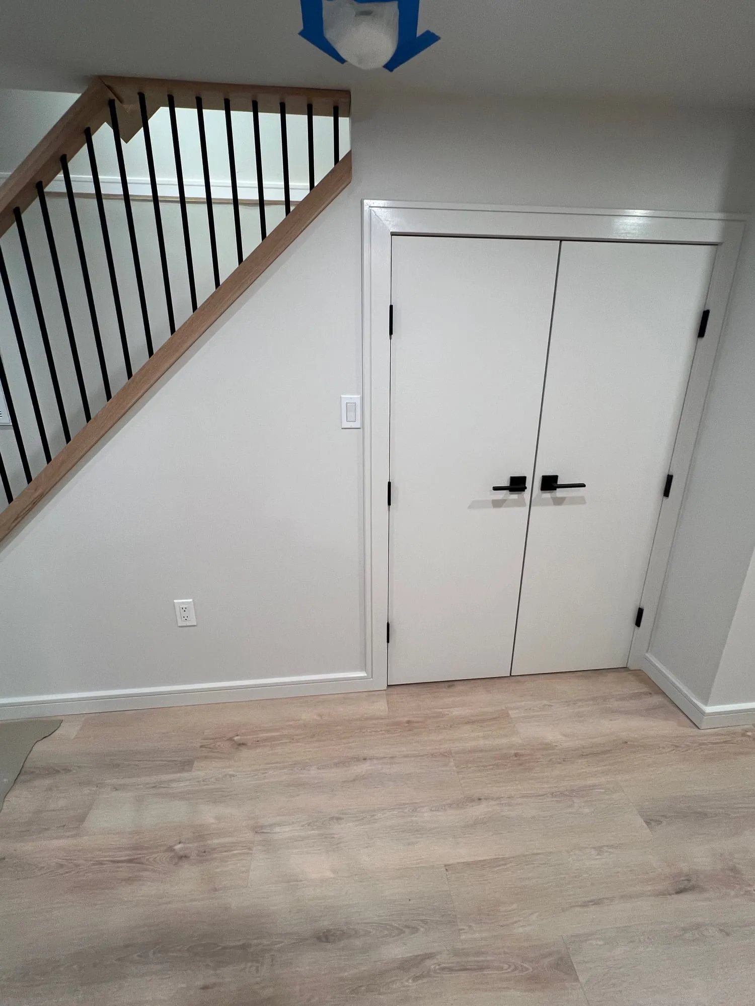 Double closet doors beside the new staircase with black metal balusters