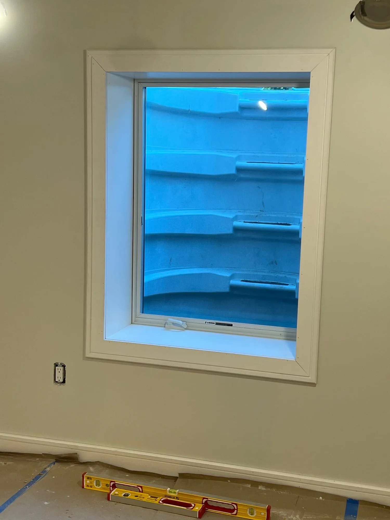 New egress window and window well installed in an East Hills basement
