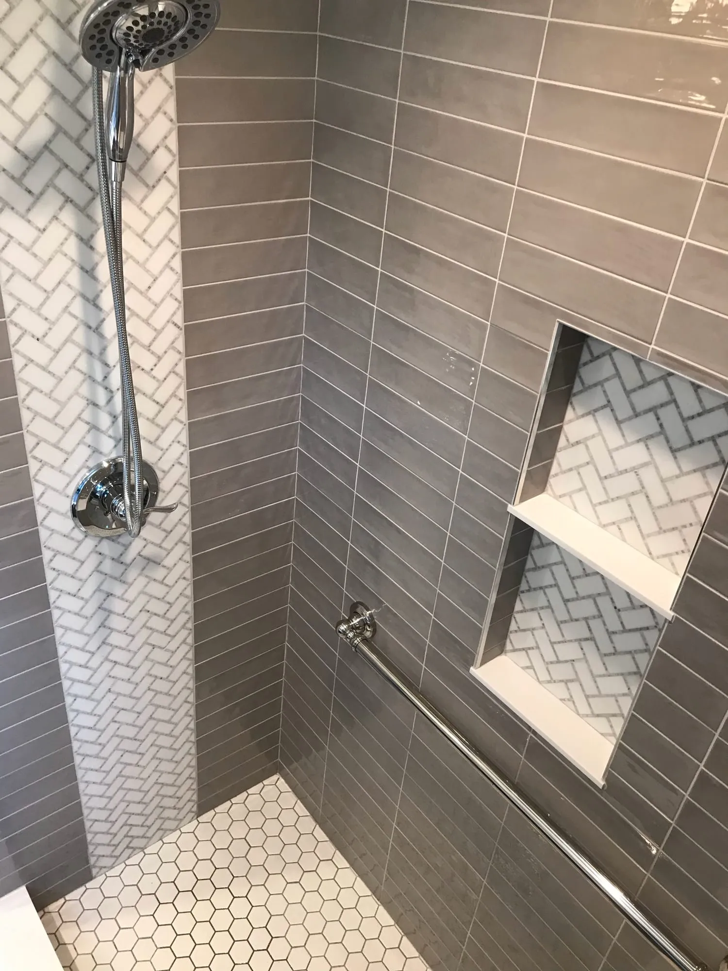 Shower niche, grab bar and hexagon mosaic floor before glass installation