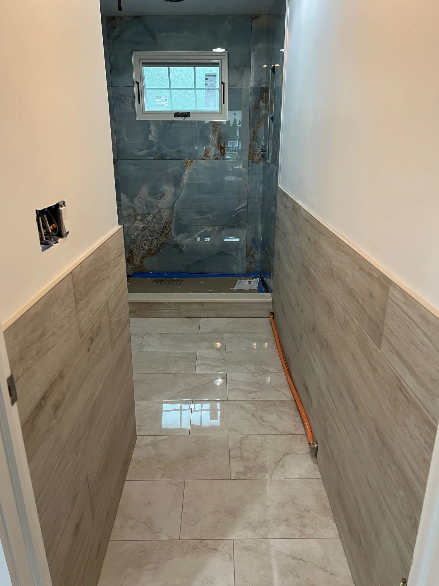 Bathroom during finishing, with floor protection still in place