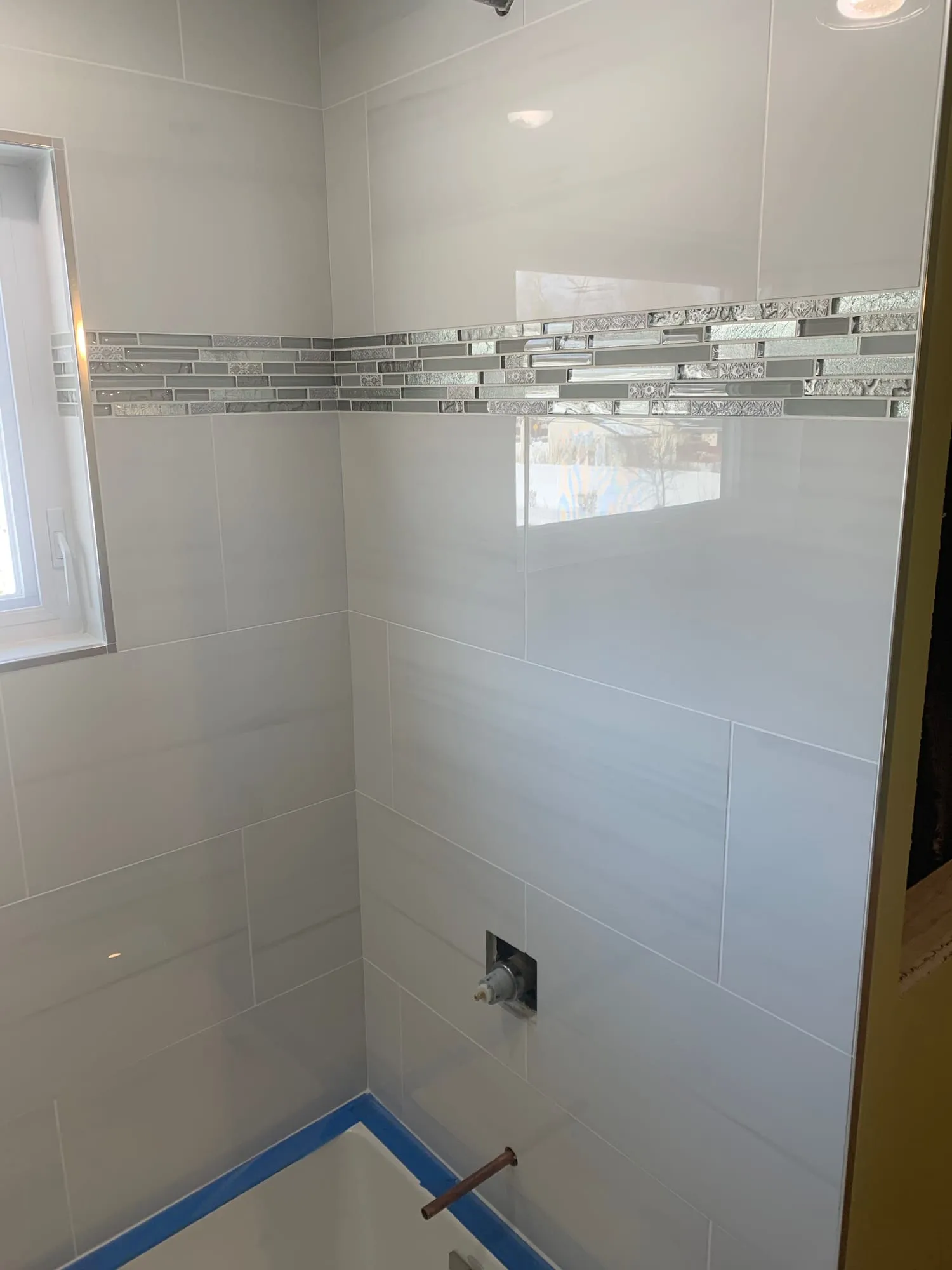 Tub surround tile and mosaic accent band before fixtures were installed