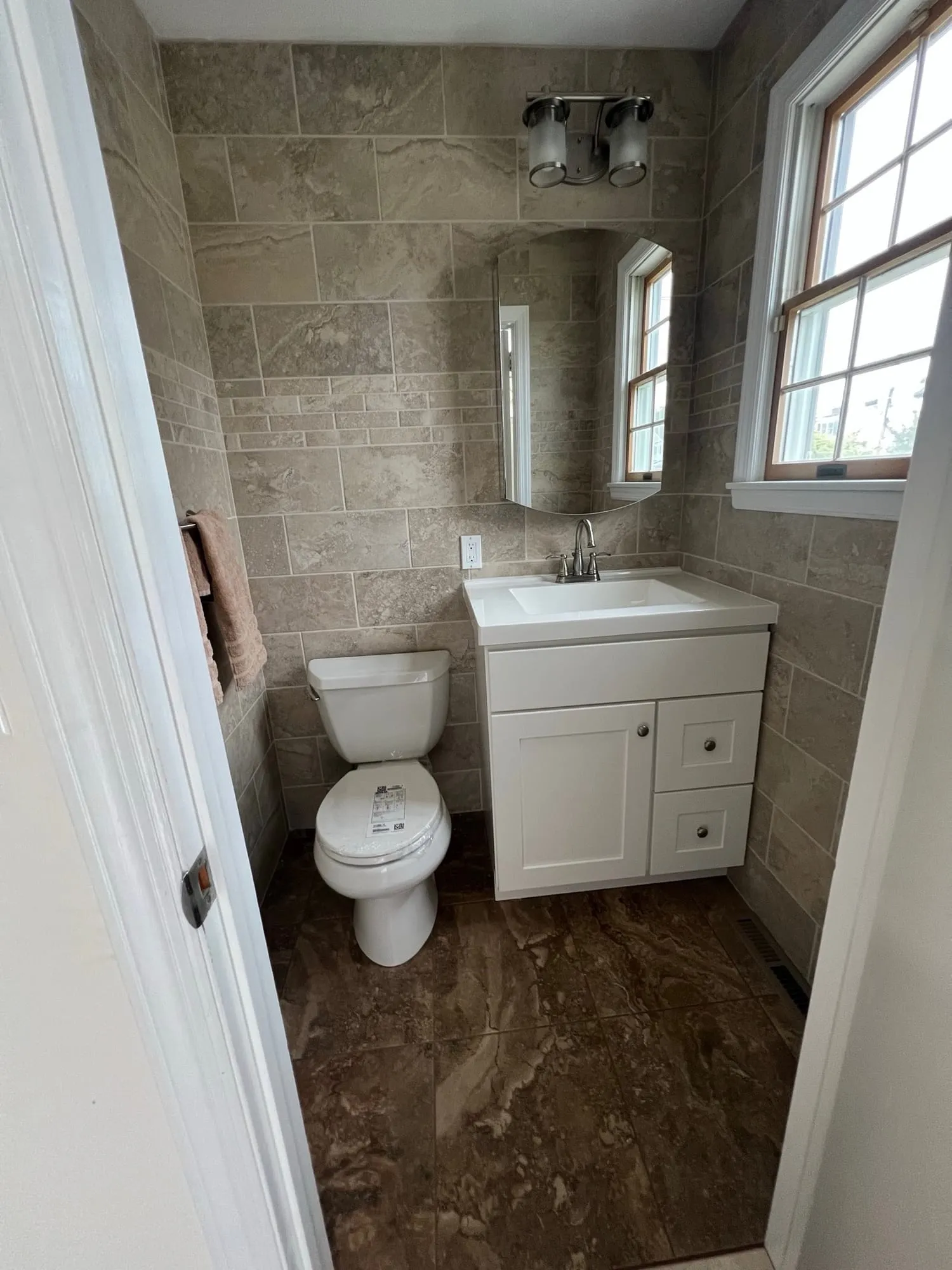 Half bath with tiled walls and a white shaker vanity